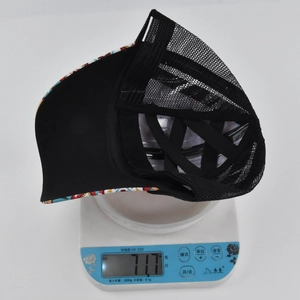 Lightweight black mesh baseball cap with tribal pattern brim on scale weighing 71.7g