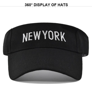Detail of white NEW YORK embroidery on a black sun visor hat with a knitted cotton texture