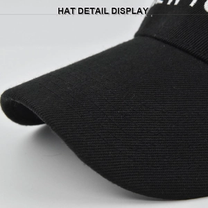 Close-up of black cotton twill visor with reinforced stitching and white letter embroidery