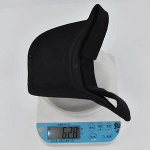 Detail view of a lightweight black sports visor weighing only 62.8 grams on a scale