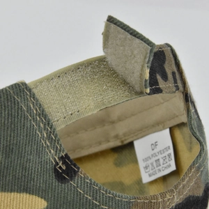Detail of kids camo baseball cap showing the adjustable velcro strap and wash care label