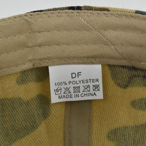 Detail view of polyester sweatband and care label inside camouflage baseball cap