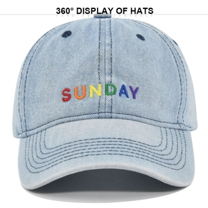 Detailed close-up of light blue denim cap with rainbow SUNDAY embroidery and stitching
