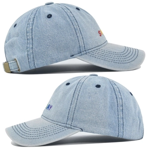 Detail view of Sunday embroidery and stitching on light blue denim baseball cap