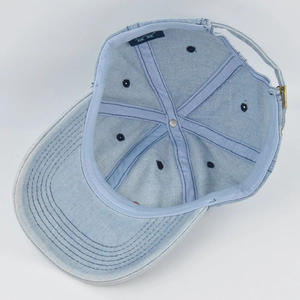 Detailed interior of denim baseball cap with adjustable strap and metal buckle