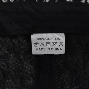 Close-up of baseball cap wash care label showing 100% cotton fabric and care symbols