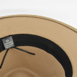 Dettaglio dell'interno del cappello di feltro con etichetta 100% poliestere e taglia 57