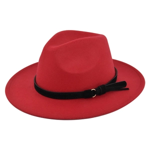 Detail of red wool felt fedora featuring a black leather band and gold metal buckle