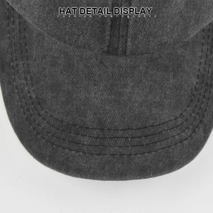 Detailed macro view of washed dark grey cotton baseball cap with triple-stitched brim texture