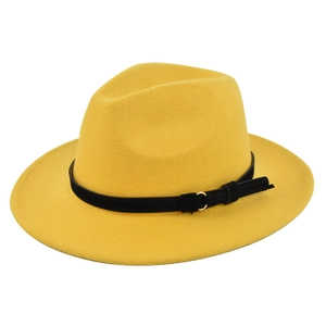 Detail of yellow fedora with black faux suede band, gold metal buckle and fringe tassel