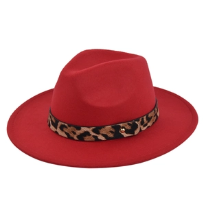 Close-up of red wool fedora hat with leopard print band and golden metal rivet detail