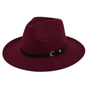 Macro detail of wine red wool fedora featuring a black leather band and gold buckle