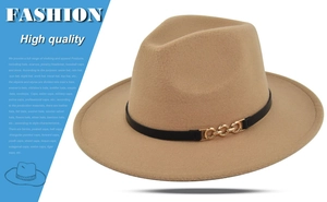 Detail view of camel fedora hat featuring black decorative band and golden chain link buckle