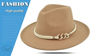 Detail of camel wool fedora hat featuring woven beige band and sparkling gold link buckle