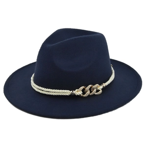 Detail of navy fedora hat with white braided rope and textured gold buckle