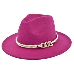 Detailed view of rose red felt fedora with white braided band and gold buckle detail