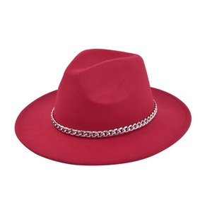 Detail of red wide brim fedora hat with elegant silver metal chain trim on wool felt