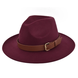 Close-up of burgundy fedora hat featuring a brown leather strap and golden metal buckle