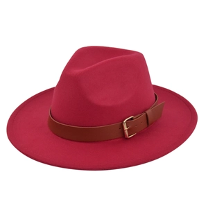 Detail of a bright rose pink wool fedora hat featuring a brown faux leather belt buckle