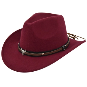 Close-up of burgundy felt cowboy hat with vintage silver bull head emblem and braided band