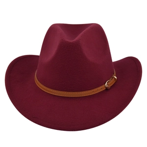 Detailed texture of burgundy felt fedora hat with brown leather belt and golden buckle