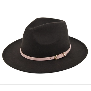 Detailed view of pink leather strap and gold buckle on a classic black wool fedora hat