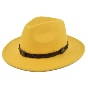 Dettaglio del cappello fedora in lana gialla con fascia in pelle marrone e borchie