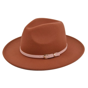 Detailed close-up of a caramel felt fedora hat with a pink leather strap and gold buckle