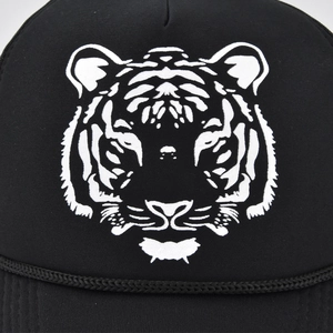 Makroaufnahme einer schwarzen Baseballkappe mit weißem Tigerprint und dekorativem Seil