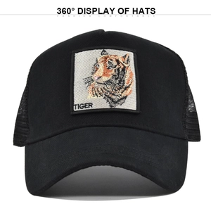 Close-up of black trucker hat with detailed tiger embroidery patch and mesh back