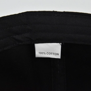 Detail shot of the black cotton baseball cap interior featuring a 100% cotton wash label