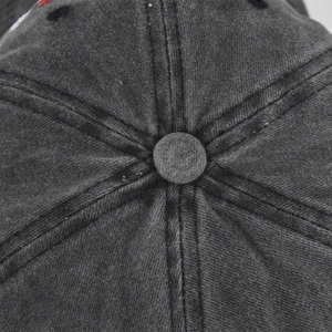 Macro detail of top button and reinforced stitching on washed cotton baseball cap