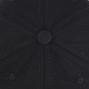 Vista macro dettagliata della corona in cotone nero e del bottone superiore di un cappello tattico