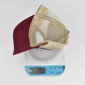 Detaillierte Gewichtsmessung zeigt ein weinrotes und beiges Trucker Hat bei 75,5 Gramm