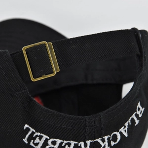 Detail der Metallschnalle und weißen BLACK LABEL Stickerei auf der schwarzen Baseballkappe