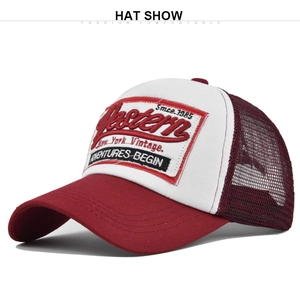 Detail of red and white mesh trucker hat with 1985 western embroidery and curved brim