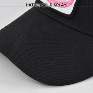 Close-up of black cotton baseball cap showing reinforced brim stitching and fabric texture