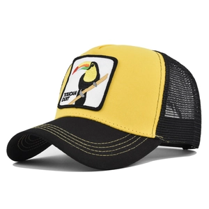 Detail of embroidered Toucan patch on yellow mesh trucker hat with contrast stitching