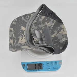 Detailed top view of a digital camo tactical cap being weighed on an electronic scale