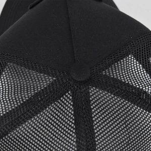 Close-up of the top button and breathable mesh texture on this black trucker cap
