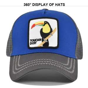 Detail of Toucan Doit embroidery patch on blue and grey mesh trucker baseball cap