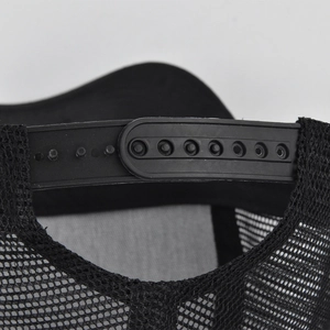 Close-up of the adjustable 7-hole plastic snapback closure on a black mesh trucker cap