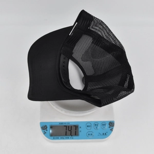 Detail shot of a black trucker hat weighing 74.7 grams on a digital scale for accuracy