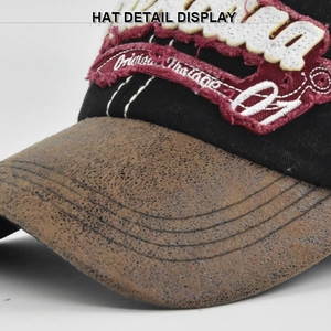 Détail macro d'une casquette vintage avec broderie bordeaux et visière effet vieilli