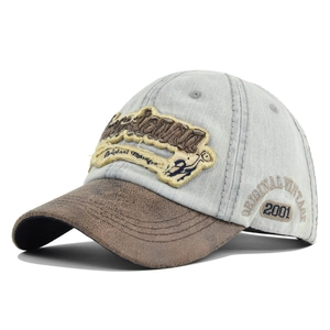 Close-up of vintage washed denim baseball cap with patch embroidery and 2001 side detail