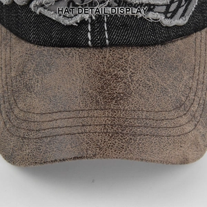 Macro detail of brown leather brim with stitching and distressed denim fabric on cap