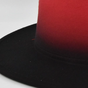Close-up of red and black gradient felt fabric texture on a wide brim jazz hat