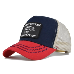 Detail of navy canvas trucker hat with red brim and fish patch embroidery