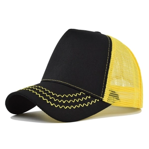 Detail of a two-tone trucker hat with yellow mesh and wave stitching on the brim