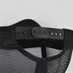 Detail of adjustable snapback closure and breathable black mesh on a trucker hat